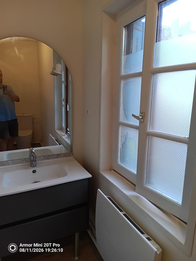 Meuble vasque avec miroir, fenêtre à petits bois et radiateur
